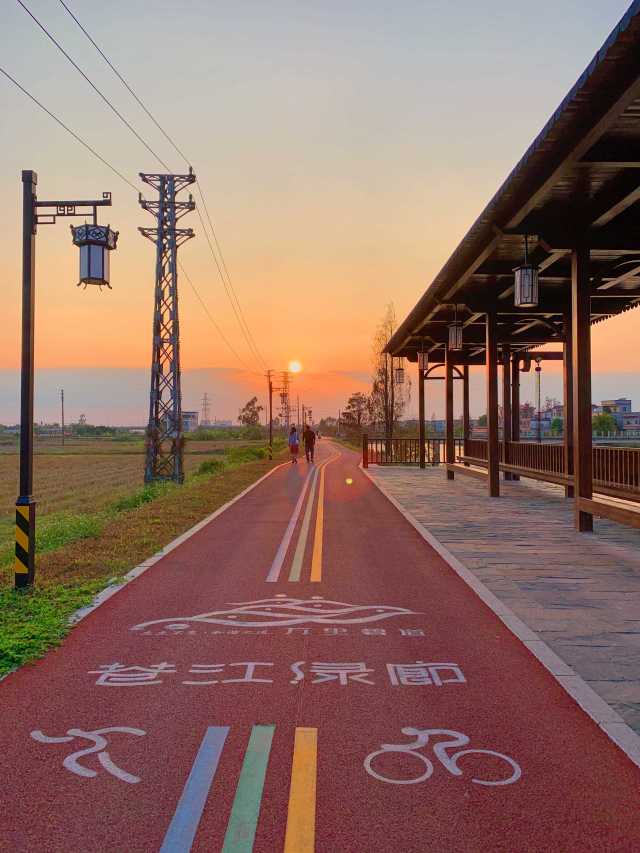 黃昏時分，人們迎著夕陽在蒼江綠廊漫步